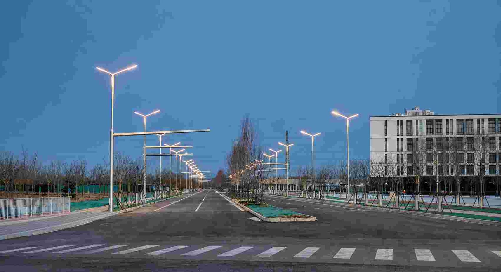 Multi-lane highway with uniform LED street lighting stretching into the distance